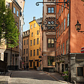 Fußgänger gehen auf der Straße neben bunt bemalten Gebäuden; Stockholm Schweden
