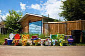 Bunte und geschmückte Toiletten reihen sich am Straßenrand vor einem Haus auf; Spruce Grove Alberta Kanada
