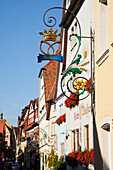 Hanging Sign With Blossoming Flowers In Window Planter Boxes; Rothenburg Ob Der Tauber Bavaria Germany