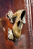 A Gold Shoe Mounted On A Wooden Door As A Door Handle; Chiclana De La Frontera Andalusia Spain