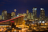 Calgary Skyline mit Saddledome in der Abenddämmerung mit Lichtern der Stadt; Calgary Alberta Kanada
