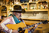 Cowboy Playing Guitar In A Saloon; Bragg Creek Alberta Canada