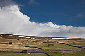 Small Structures Scattered Across A Grass Landscape With Traces Of Snow; Swaledale England