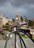 Ein Fahrrad im Vordergrund mit Häusern im Hintergrund; Muker Dorf Yorkshire England