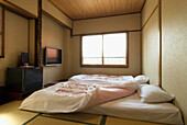 Traditionelles japanisches Schlafzimmer mit Tatami-Boden und Futon-Betten; Takayama, Gifu, Japan
