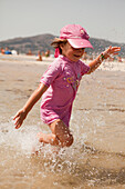 Junges Mädchen beim Planschen im Wasser am Strand; Tarifa, Cadiz, Andalusien, Spanien