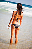 Eine Frau in einem schwarzen Bikini am Meer; Gold Coast Queensland Australien