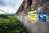 Signs Posted On A Weathered Wall Of A Police Station Building; Gesher Israel