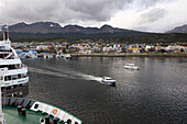 Boats In The Water And Cityscape With Mountains In The Distance; Ushuaia Argentina