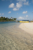 Panama, San Blas Inseln (auch Kuna Yala Inseln genannt), Yandup Insel, kleiner Strand mit Boot am Dock.