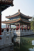 A Crowd Gathers Under A Traditional Chinese Structure; Beijing China