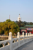Geländer und Promenade am Wasser mit einem bunten Gebäude und Turm; Beijing China