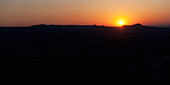 Silhouette Of The Landscape And An Orange Horizon With A Glowing Sun At Sunset; Aktepe Nevsehir Turkey