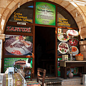 Vorderseite eines Restaurants mit Bildern von Speisen, die um den Türrahmen herum beworben werden; Mustafapasa Nevsehir Türkei