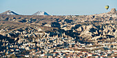 Hot Air Balloon In Flight Above The City; Goreme Nevsehir Turkey