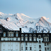 Ein Hotel mit den verschneiten französischen Alpen im Hintergrund; Chamonix-Mont-Blanc Rhone-Alpes Frankreich