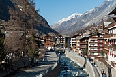 Ein Wasserweg durch die Stadt mit Fußgängern auf der Promenade; Zermatt Wallis Schweiz