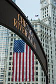 Eine amerikanische Flagge hängt an der Seite eines Gebäudes mit dem Zeichen des Chicago Riverwalk; Chicago Illinois Vereinigte Staaten von Amerika