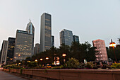 Laternenpfähle entlang einer Promenade mit Wolkenkratzern im Hintergrund in der Abenddämmerung; Chicago Illinois Vereinigte Staaten von Amerika