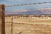 Ruinen einer jüdischen Siedlung am Toten Meer, gesehen durch einen Stacheldrahtzaun; Israel