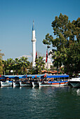 Türkei, Westliches Mittelmeer, Dalyan, Touristenboote entlang des Ufers vor dem Minarett