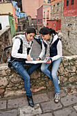 Zwei junge Frauen betrachten einen Stadtplan im Stadtzentrum; Guanajuato, Bundesstaat Guanajuato, Mexiko