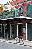 USA, New Orleans, Louisiana, Fahrrad lehnt an Mast vor Restaurant