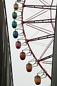 Ferris wheel with colorful passenger cars; Tokyo, Japan