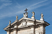 Italien, Emilia-Romagna, Ferrara, Kirchenschmuck mit Statuen und Kreuz vor blauem Himmel