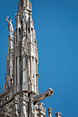 Close up of cathedral spire with gargoyle and blue sky; Milano, Lombardia, Italy