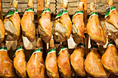 Parma hams hanging in store display; Parma, Emilia-Romagna, Italy