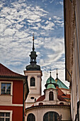 Czech Republic, Buildings with green roofs and spire on tower; Prague