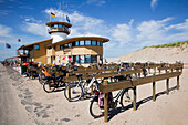 Netherlands, Zealand, Bikes parked and locked along wooden posts and beams at beach; Vlissingen