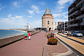 Niederlande, Seeland, Fußgänger auf der Promenade entlang des Meeres mit Gebäuden in der Stadt; Vlissingen