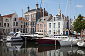 Niederlande, Seeland, Boote im Hafen und Gebäude am Wasser; geht