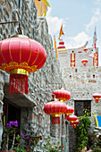 Thailand, Red and gold lanterns hanging in row outside buildings; Shandicun