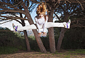 Spain, Andalusia, Cadiz, Mid Adult Woman Jumping With Legs Apart; Tarifa