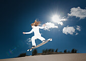 Ein Snowboarder mitten in der Luft an einem sonnigen Tag; Tarifa, Cádiz, Andalusien, Spanien