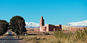 A Road Going By A Temple With Blue Sky And The Atlas Mountains; Souss-Massa-Draa, Morocco