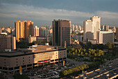Stadtbild mit Gebäuden, einer Straße und einem Parkplatz; Peking, China