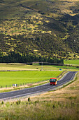 A Bus Drives Down A Scenic Stretch Of Road Just Outside Of Hyde In New Zealand's Otago Region; New Zealand