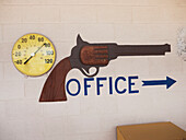 Schild mit dem Bild einer Wild West Six-Shooter Pistole auf einem Wohnmobilpark, um das Büro zu finden; Dodge City, Kansas, Vereinigte Staaten von Amerika
