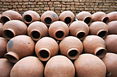 Handgefertigte traditionelle keramische Wassertöpfe, die neben einem Brennofen aufgestapelt liegen; Indien