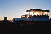Reisegruppe im Truck bei Sonnenuntergang Monument Valley, Arizona, USA