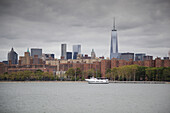 Skyline von New York City mit One World Trade Center und Ausflugsboot auf dem East River, New York, USA