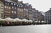Buildings and restaurant patios in Old Town Market Square, Old Town, Warsaw, Poland.