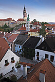 Overview of city and rooftops with the tower of St Jost Church and the tower of Cesky Krumlov Castle in the background, Cesky Krumlov, Czech Replublic.