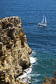 Segelboot und Klippen bei Lagos, Algarveküste, Portugal