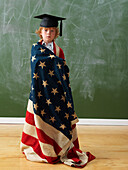 Junge mit amerikanischer Flagge und Schulabschlusshut