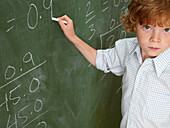 Portrait of Boy Writing on Blackboard